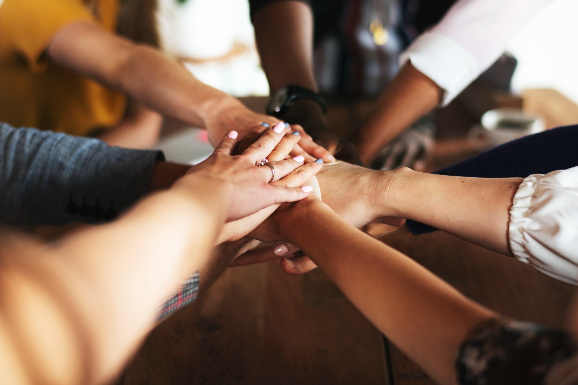 Mãos unidas de pessoas de diferentes origens, simbolizando cooperação
